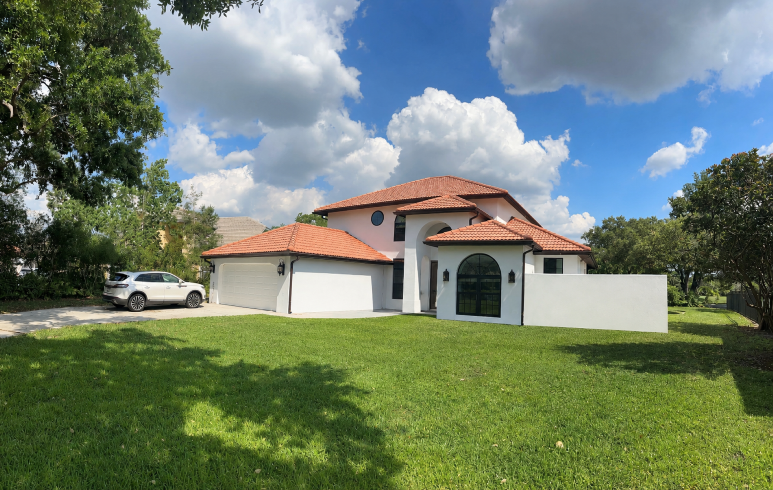 Builder-grade sod front lawn with two small identical palms before custom design in Jupiter Florida