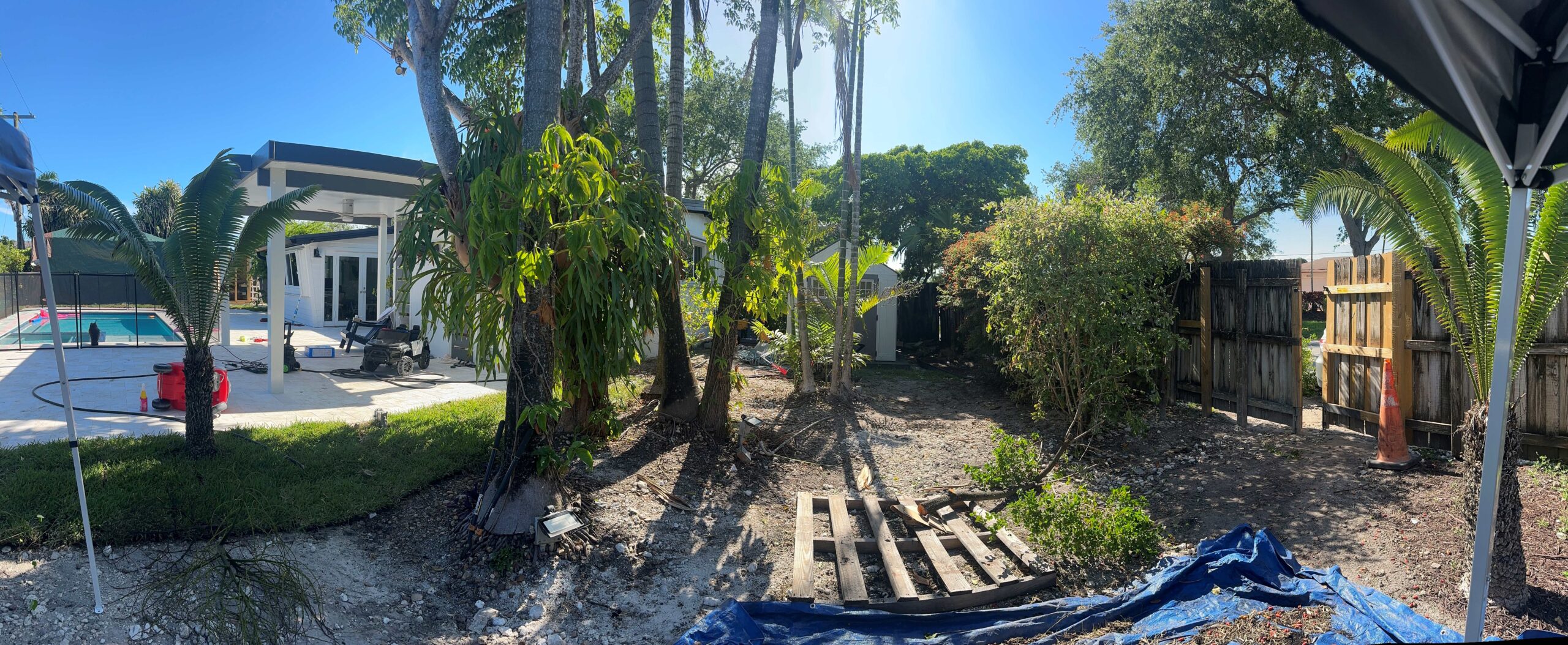 Eroded grass shoreline yard and unpaved backyard before coastal landscape redesign in Panama City