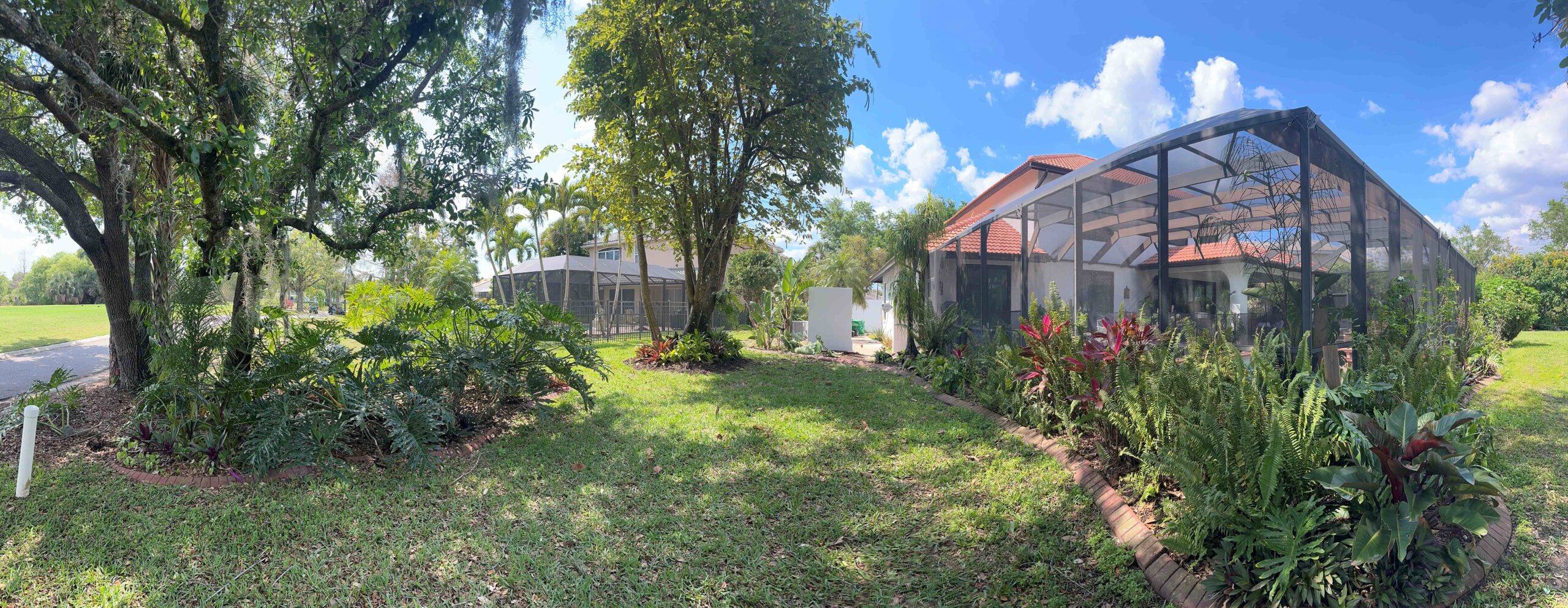Cluttered gravel side yard and weathered wooden fence before tropical garden makeover in Key West Florida