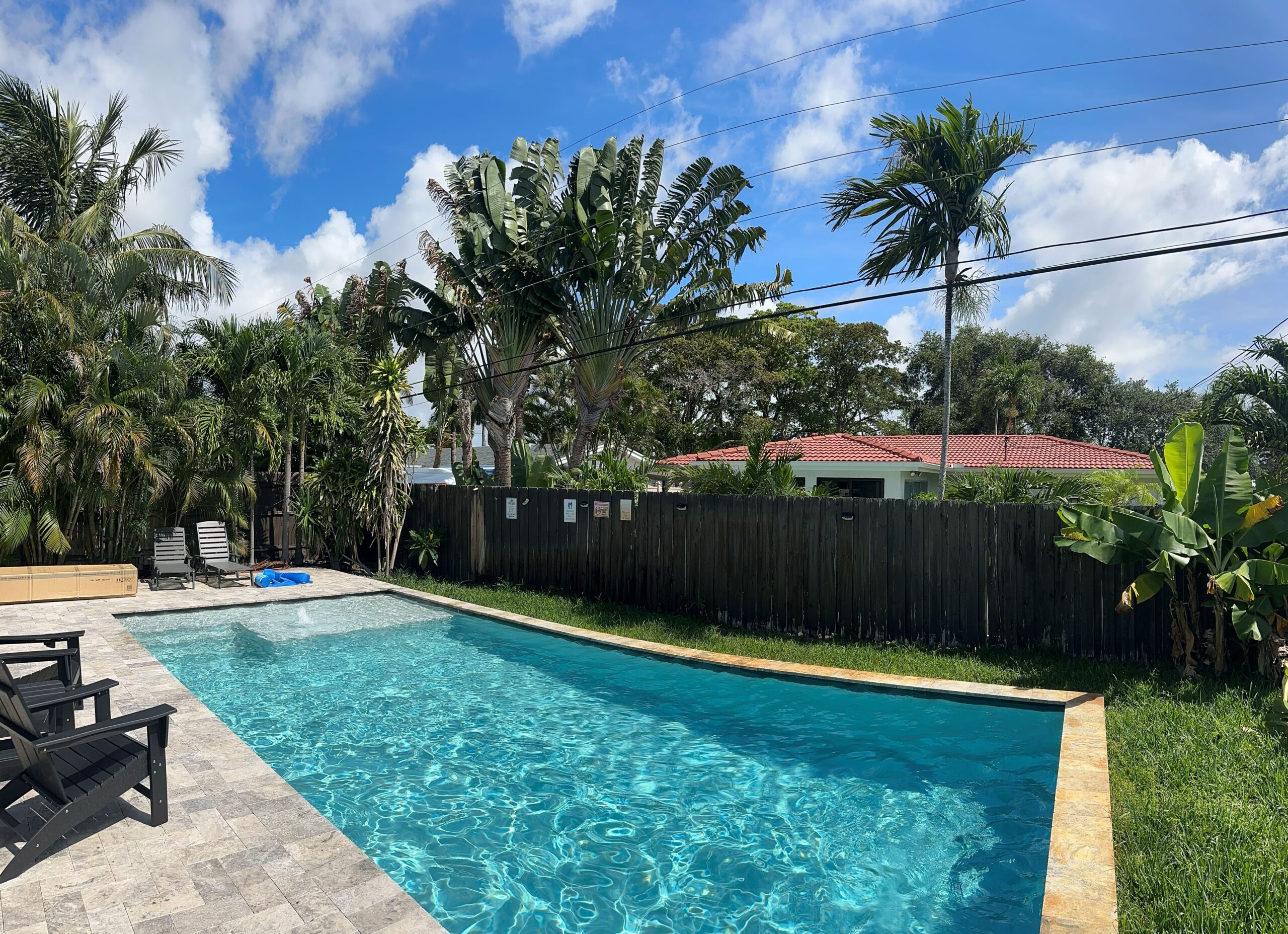 Plain canal-front backyard with deteriorating seawall edge and sparse plantings in Fort Lauderdale Florida