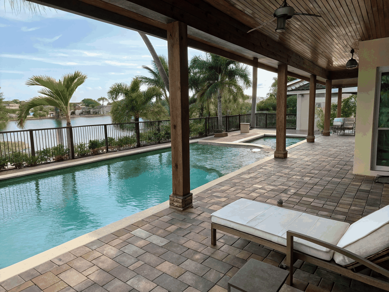 Photorealistic 3D architectural rendering of a modern Florida coastal pool with lush tropical landscaping